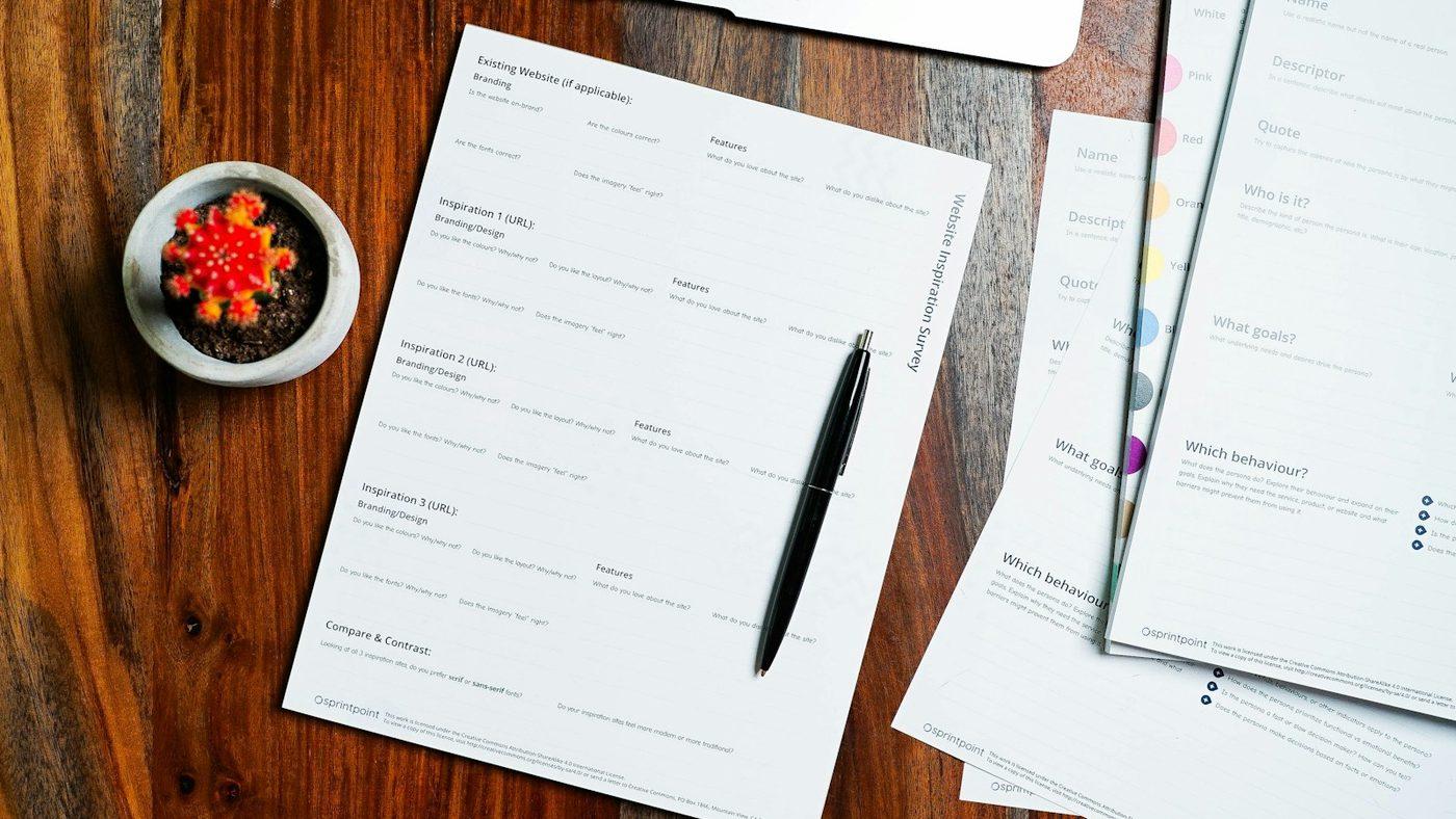 Ingevulde formulieren met een pen op een houten bureau