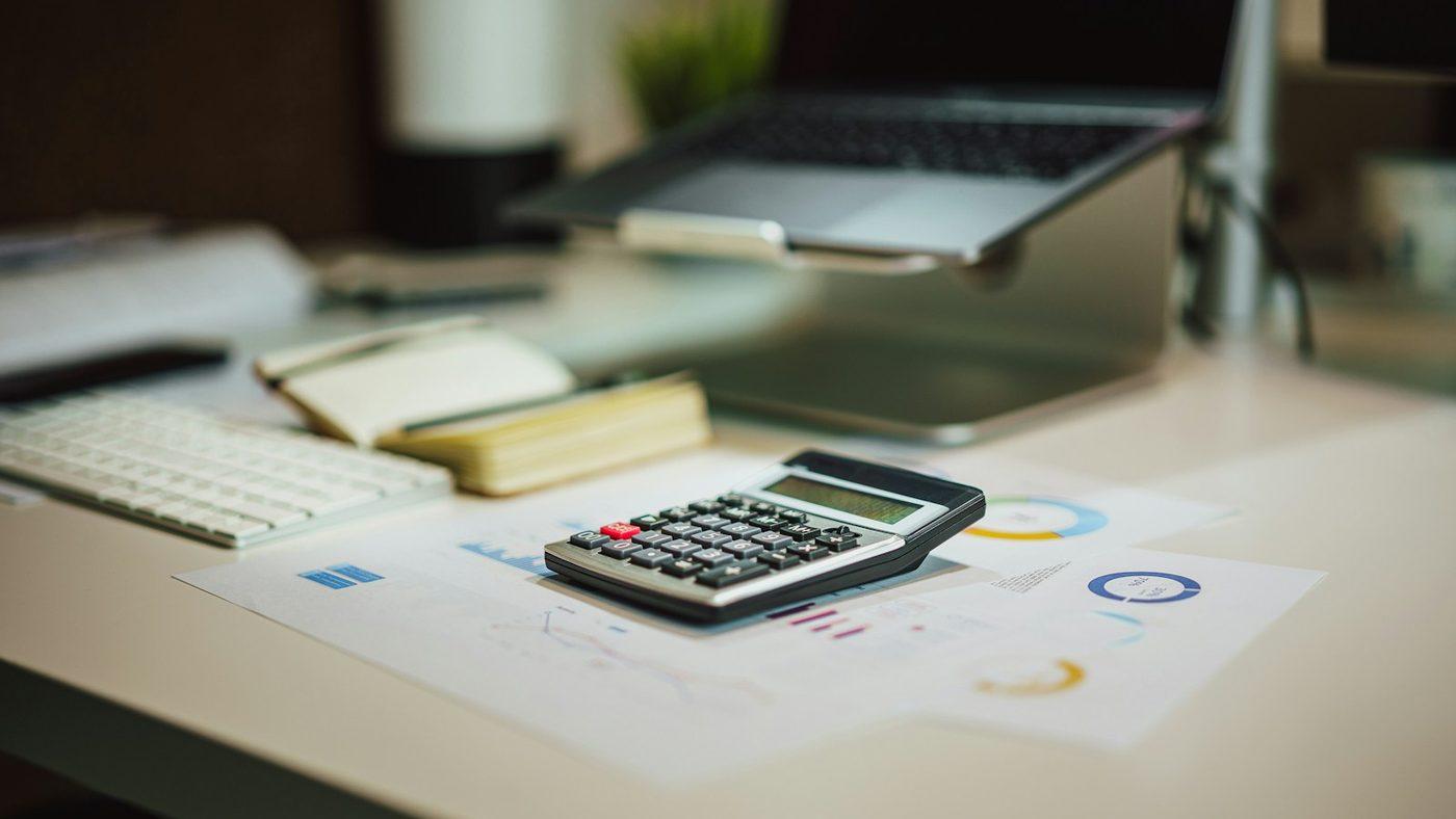 A calculator on reports with charts on a desk